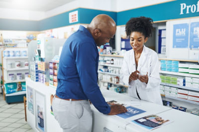 Pharmacist, woman and medicine for customer in clinic of product care, advice and information for prescription. Healthcare, person and patient with pills for pharmaceutical, instructions and safety